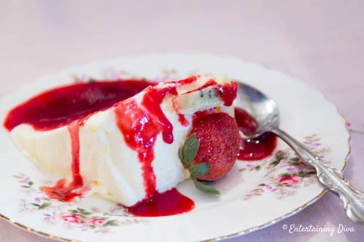 Slice of frozen lemon mousse with raspberry sauce on a plate