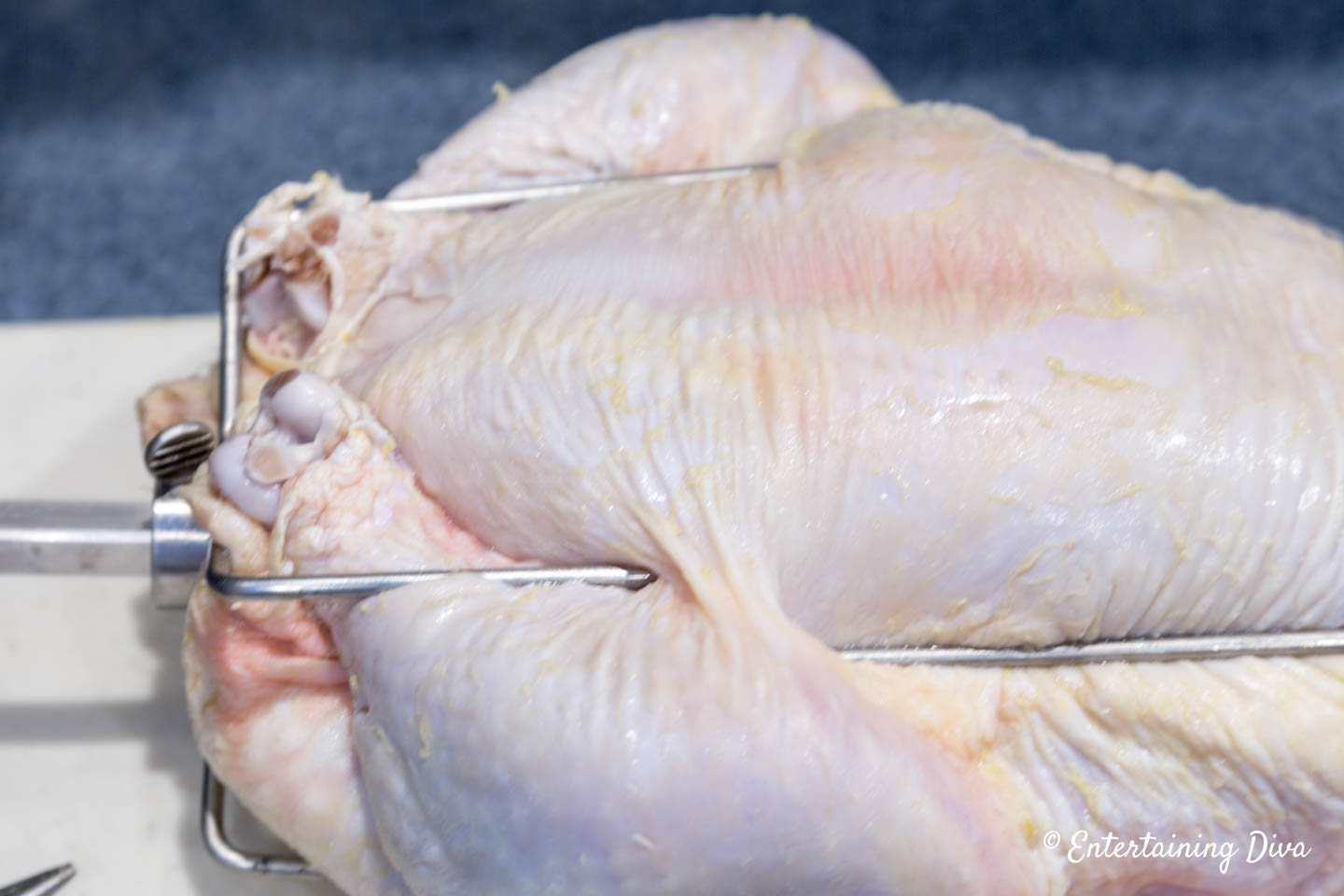 Chicken legs being held by rotisserie spit