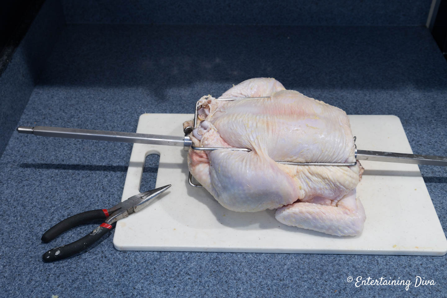 chicken on a rotisserie spit on a cutting board
