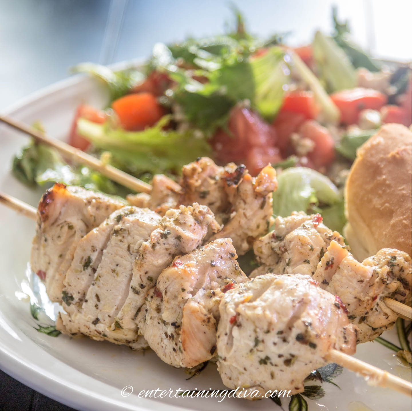 chicken shish kabobs on a plate with salad