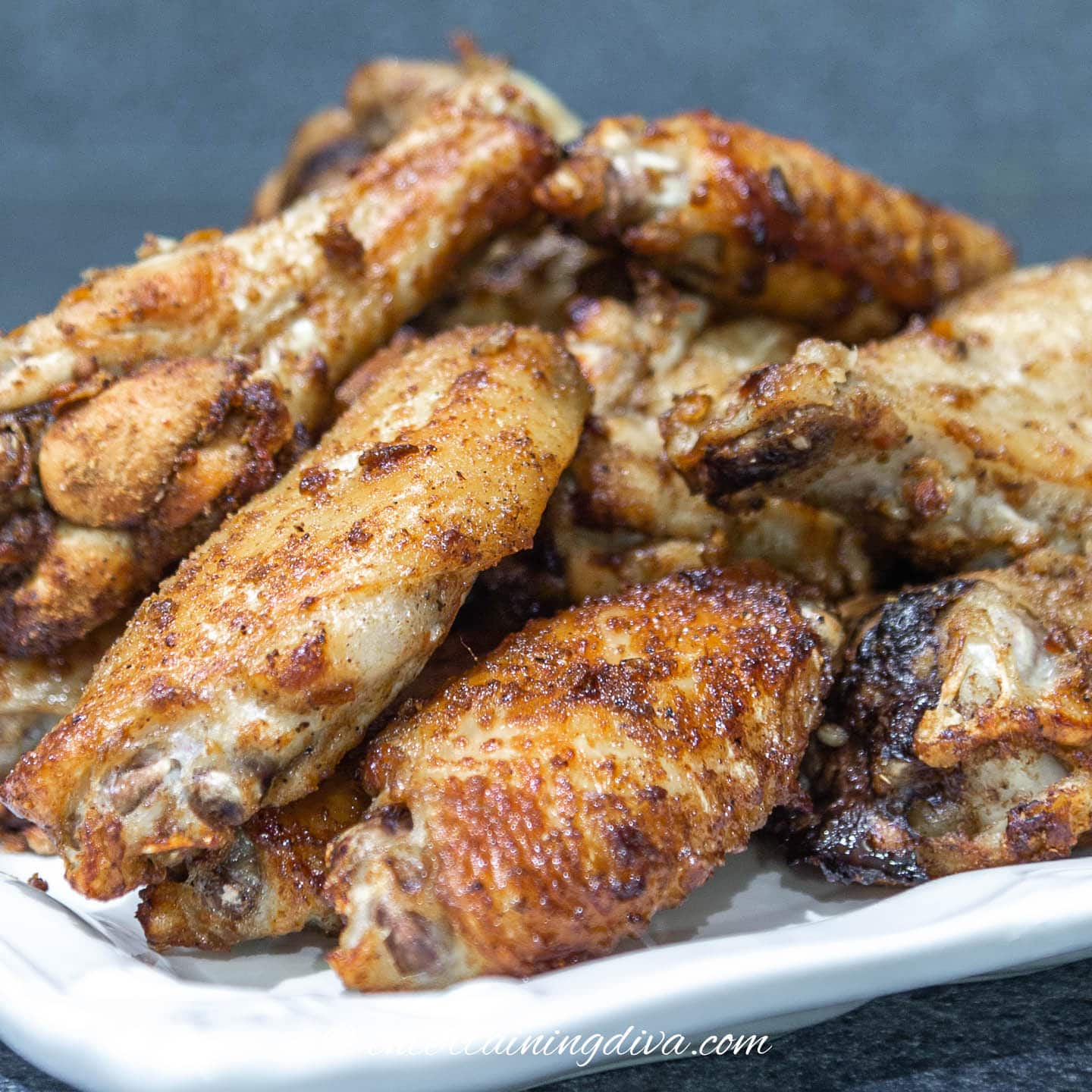 a stack of grilled marinated spicy chicken wings