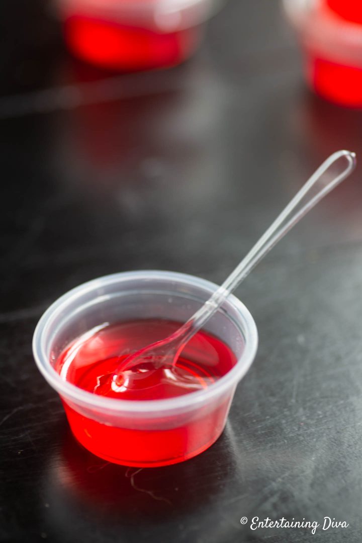 Strawberry Margarita jello shot in jello shot cup with tasting spoon