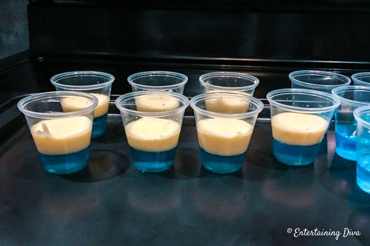 White pudding layer on top of the blue jello layer in the jello shot cups