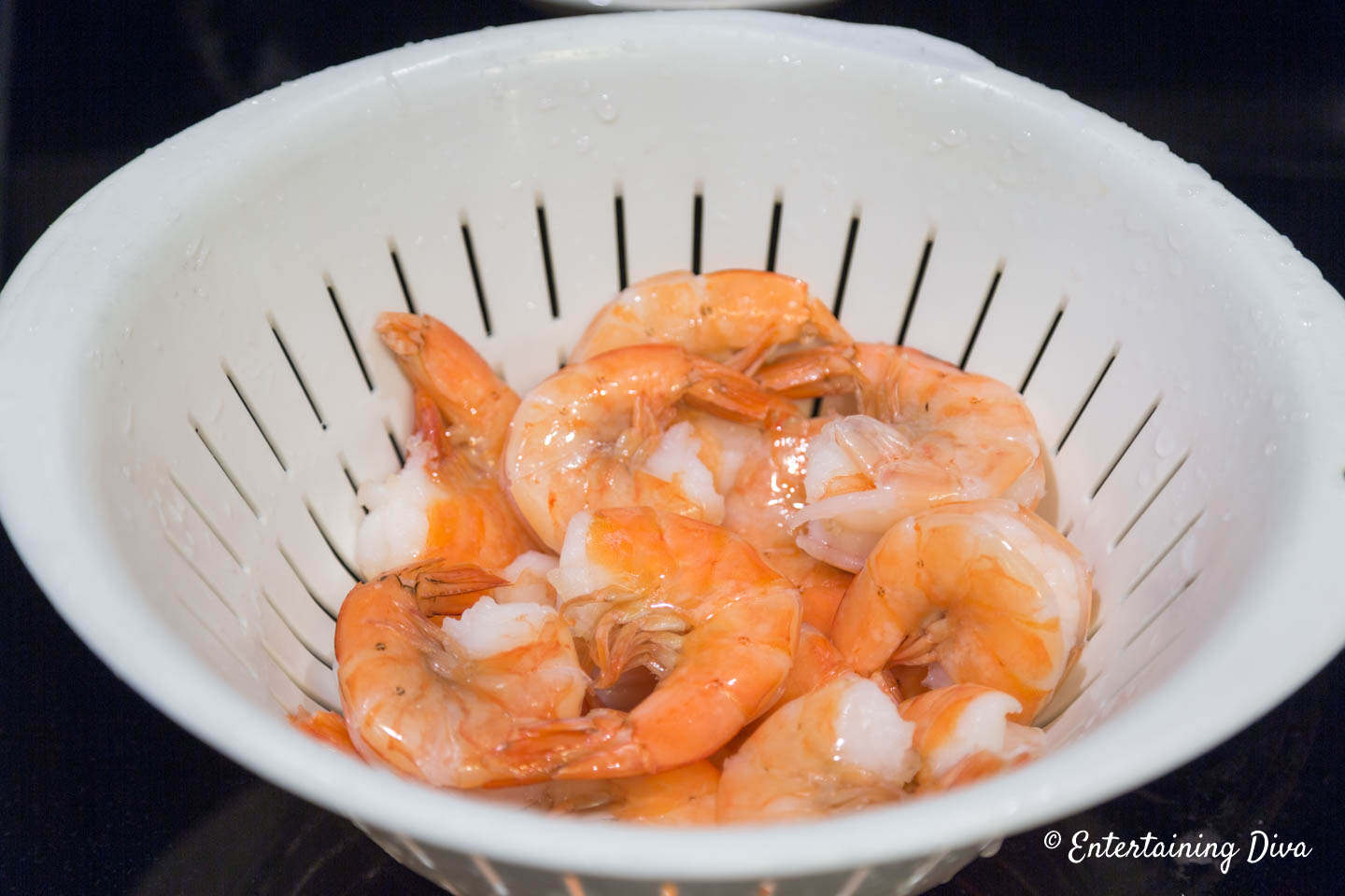 Cooked shell-on shrimp in a colander