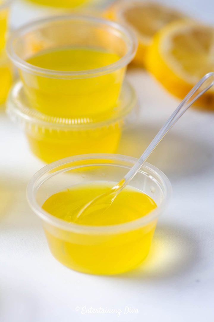 Lemon drop jello shots recipe in a jello shot cup with a mini tasting spoon
