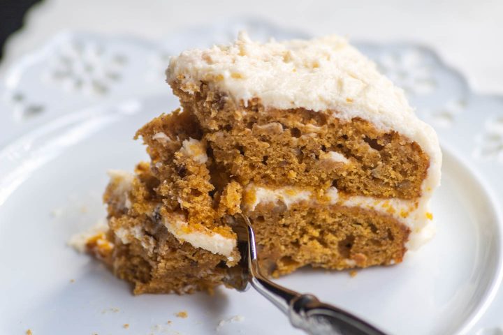 Pumpkin spice cake with ginger cream cheese icing with a fork cutting it