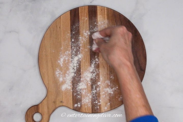 Sprinkling flour on a wood cutting board
