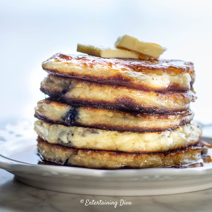 A stack of gluten-free buttermilk pancakes with butter and maple syrup