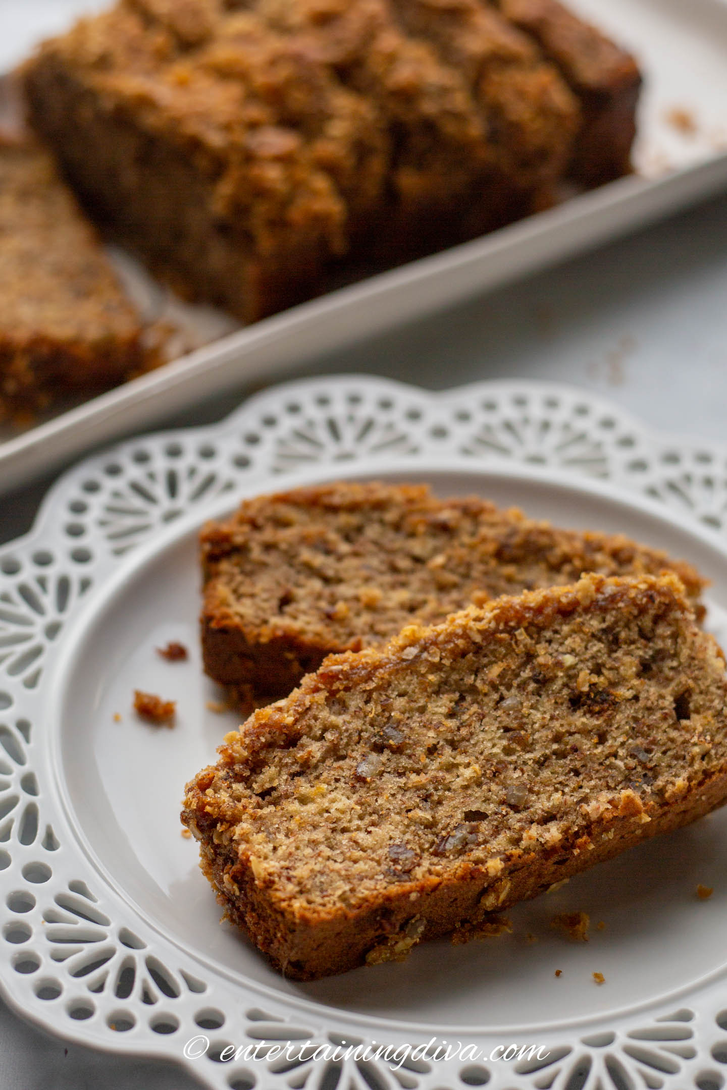 Two slices of classic banana nut bread with streusel topping on a plate