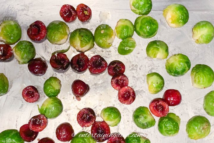 brussel sprouts and cherries spread out on a cookie sheet