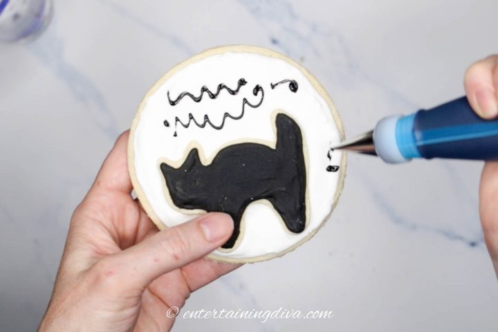 Black squiggly lines added to cat silhouette cookie