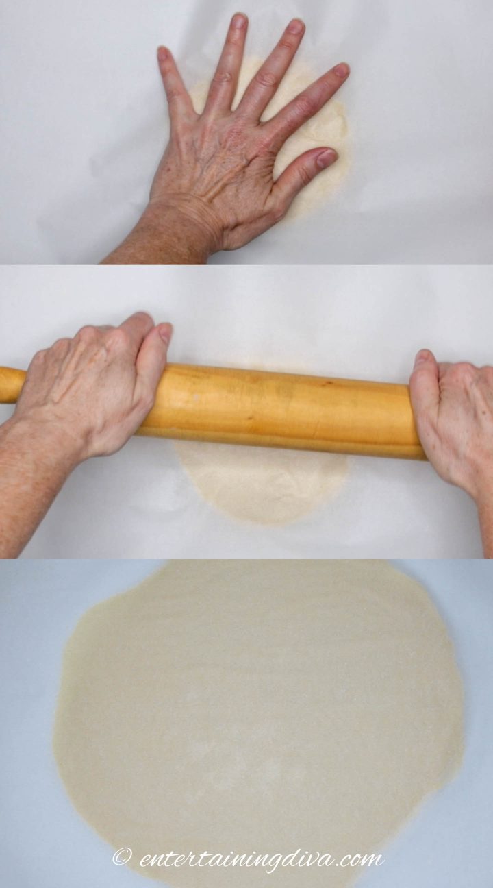 Sugar cookie dough being rolled out  between parchment paper