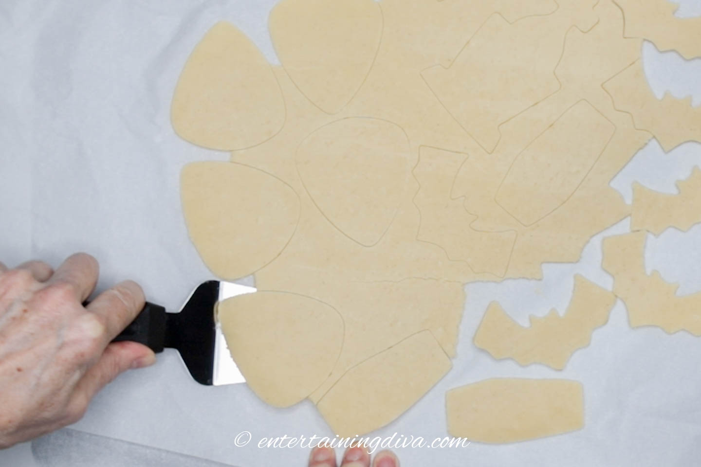 Spatula separating cookies from the parchment paper