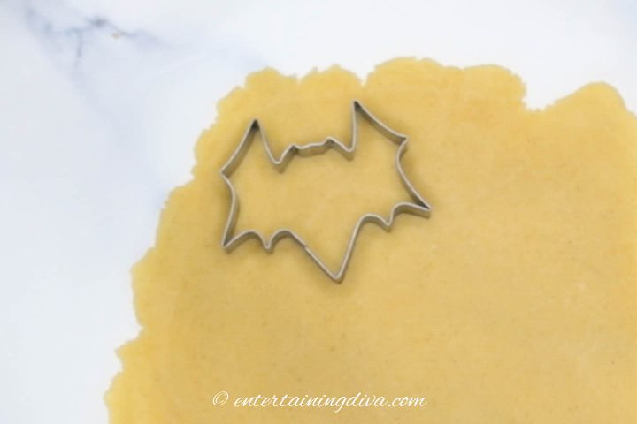 Bat cookie cutter cutting out cookie dough