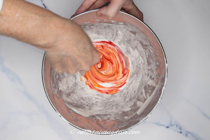 Orange color being added to royal icing