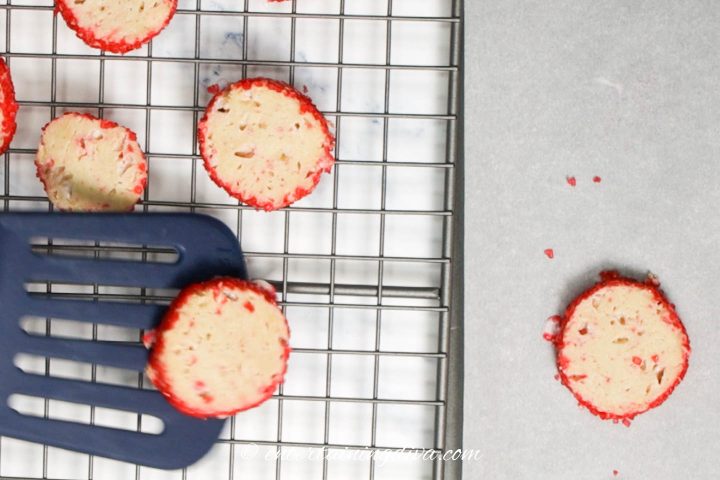 The peppermint cookies being moved onto a wire cooling rack