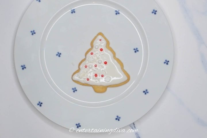 Christmas tree sugar cookies decorated with white icing and red and white sprinkles