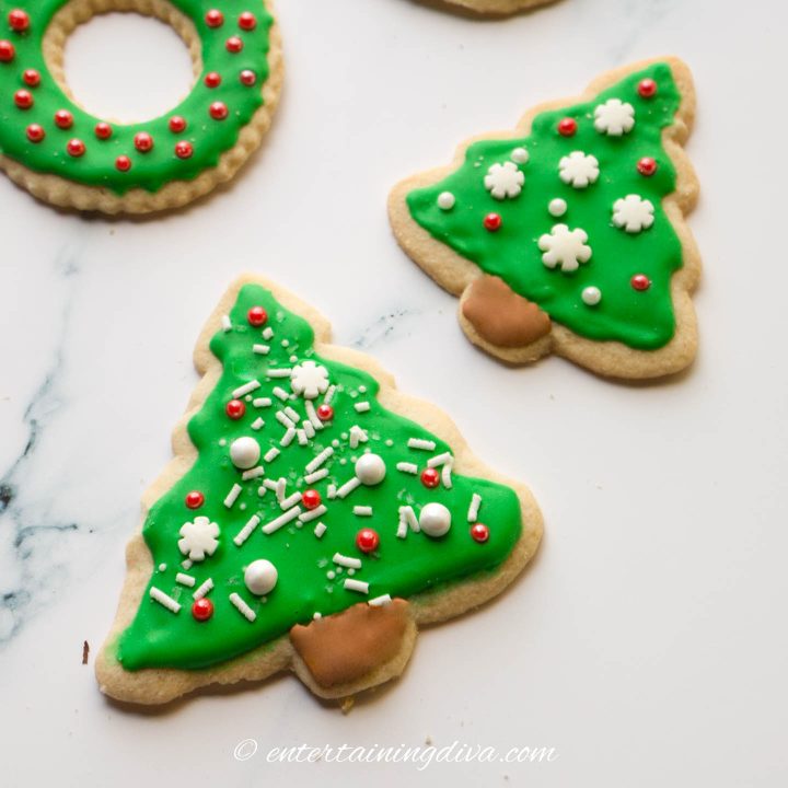 Christmas tree sugar cookies decorated with green icing and white and red sprinkles