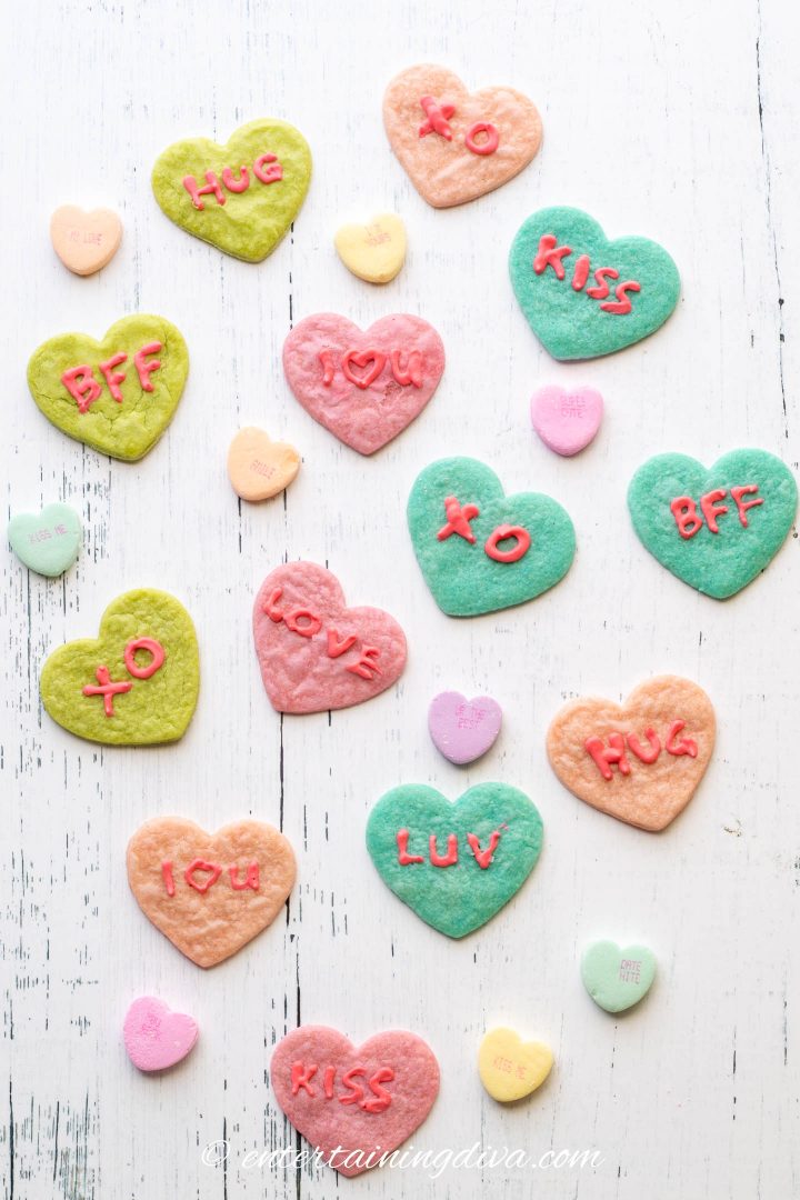 Heart cookies in different colors of cookie dough with conversation heart sayings in red royal icing
