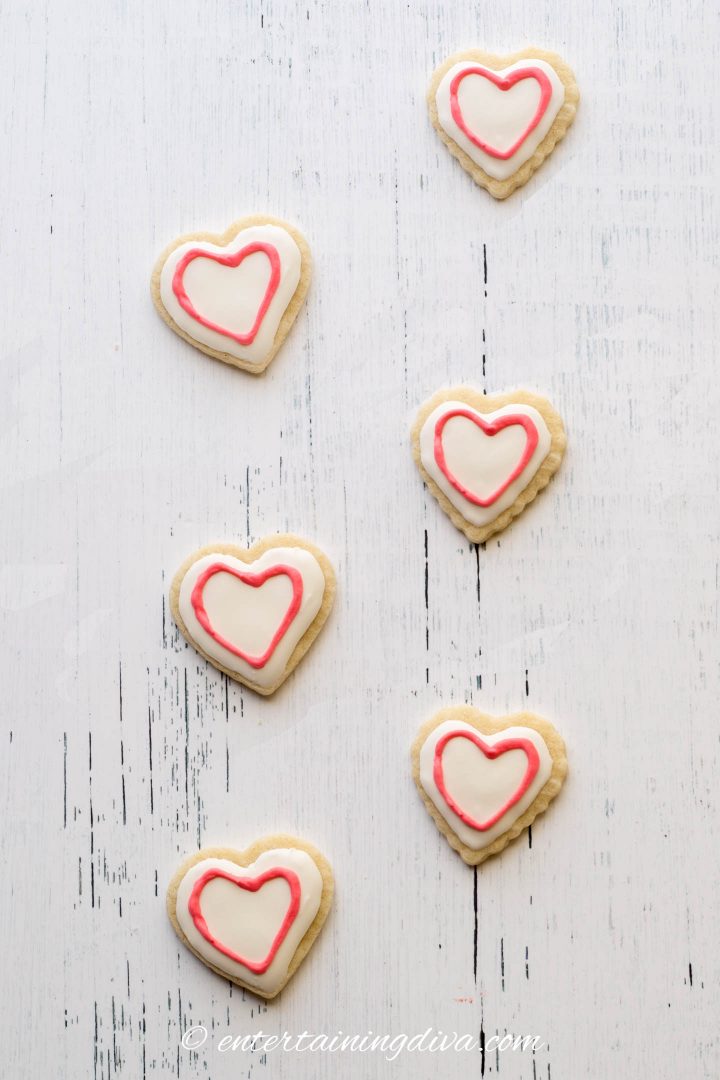 Heart cookies decorated with white royal icing and red outline