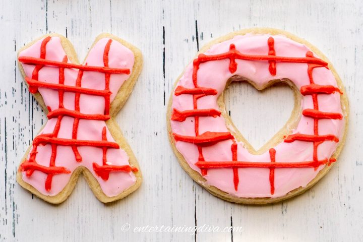 Valentine cookies in an X O shaped decorated with pink royal icing and red criss-cross pattern