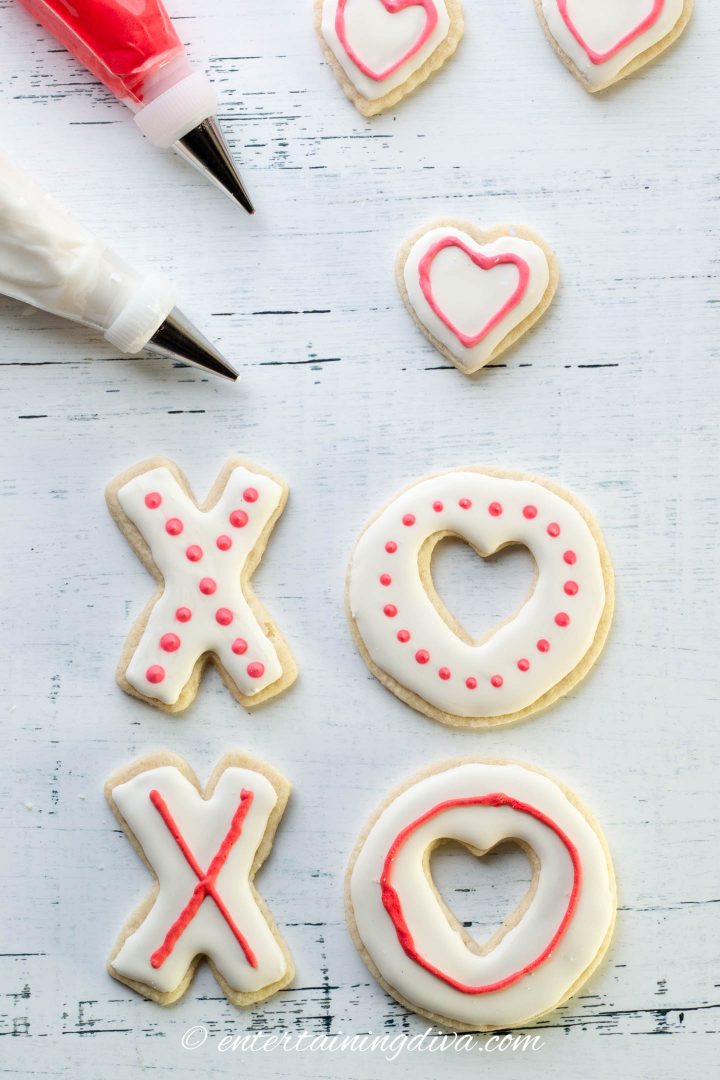 Cookies in an X and O shape decorated with white royal icing and red dots
