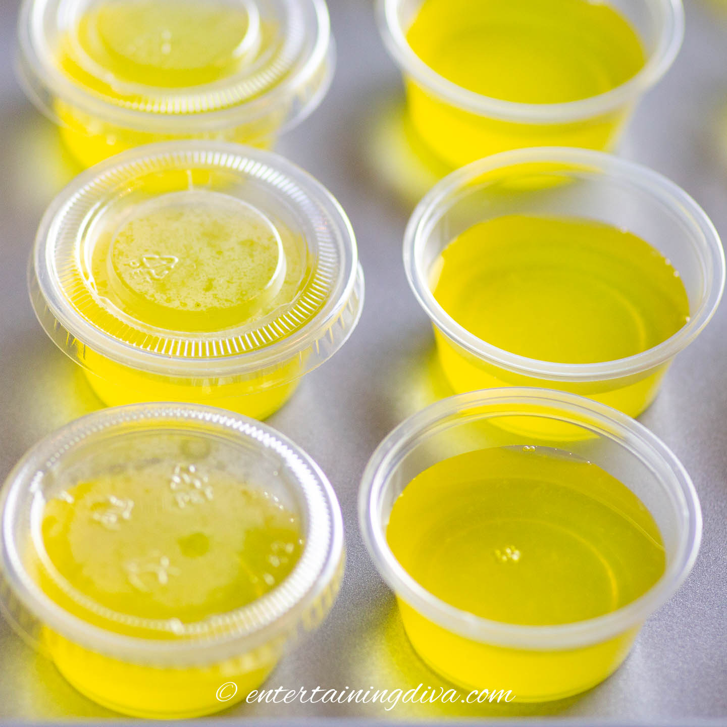 close up of jello shot cups filled with yellow pina colada jello shots