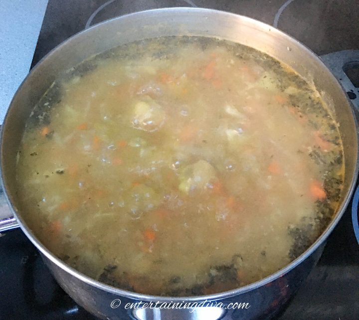 split pea soup simmering in a stock pot on the stove