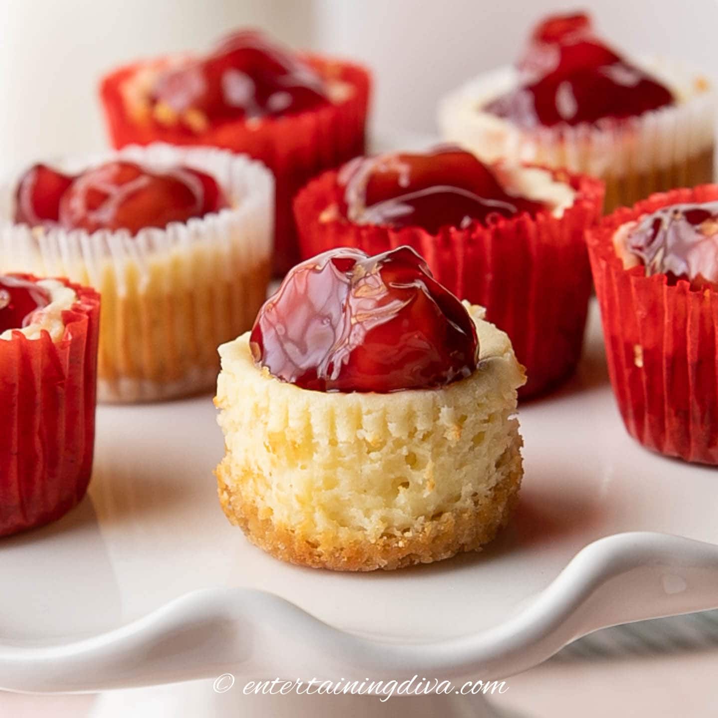 mini cherry cheesecakes with a vanilla wafer crust on a tray