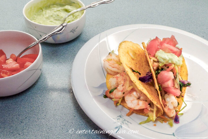 shrimp tacos served with tomatoes and guacamole