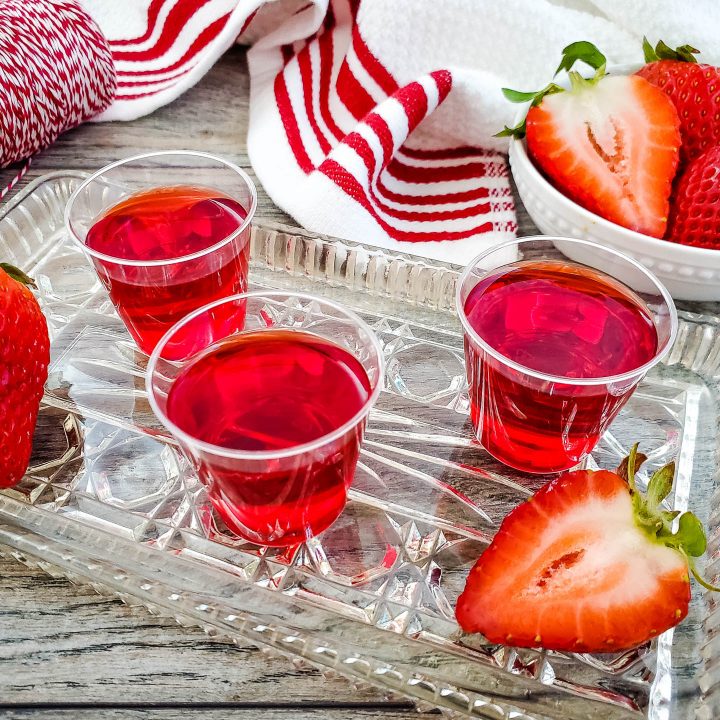 apple strawberry jello shots on a tray