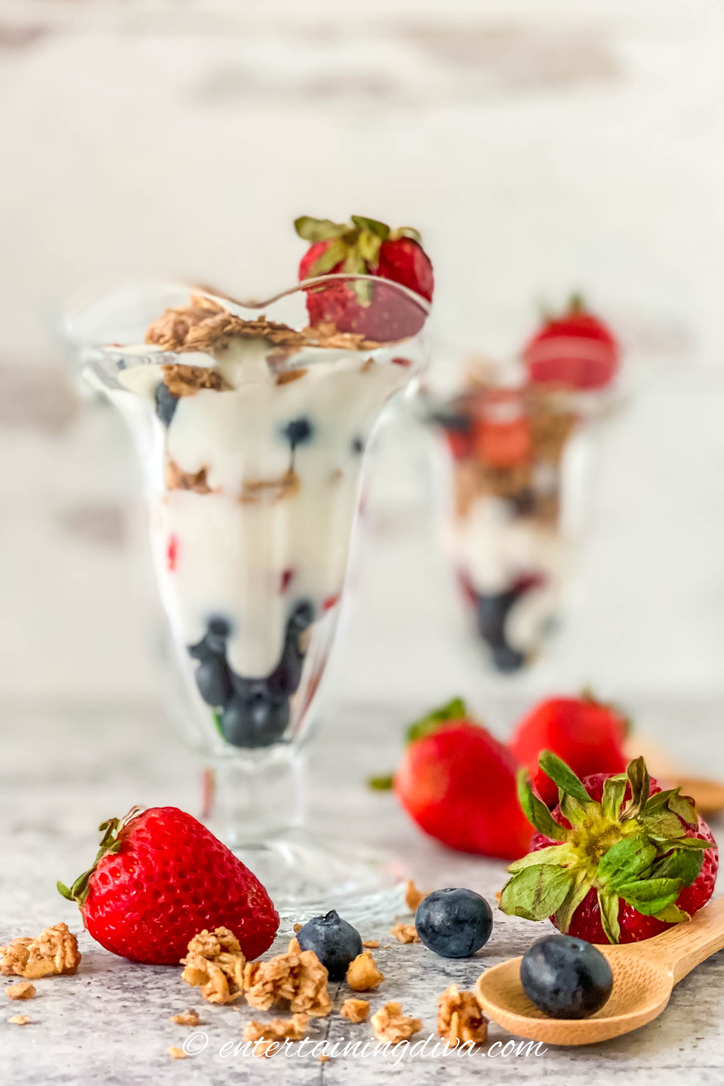 strawberry blueberry yogurt parfait in a tall glass