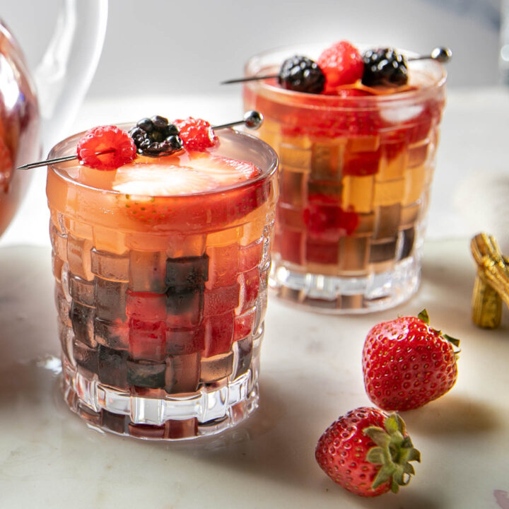 two glasses filled with triple berry sangria and fresh berries
