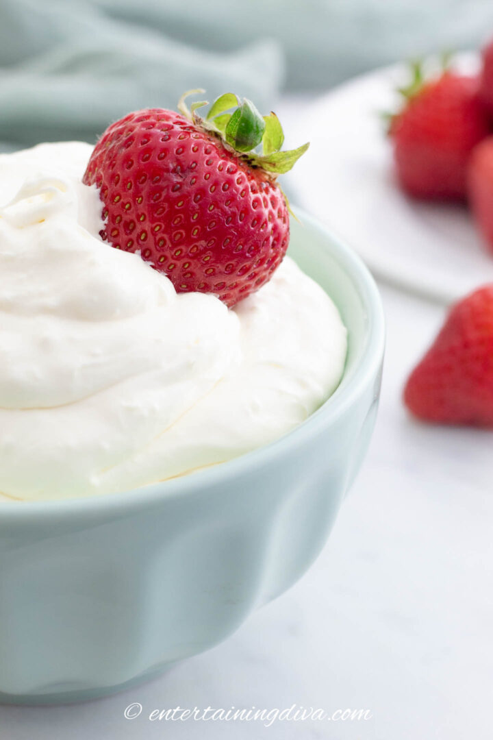 Strawberry being dipped in cream cheese fruit dip