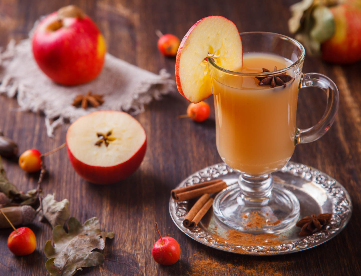 homemade spiced apple cider in a glass with a slice of apple for garnish