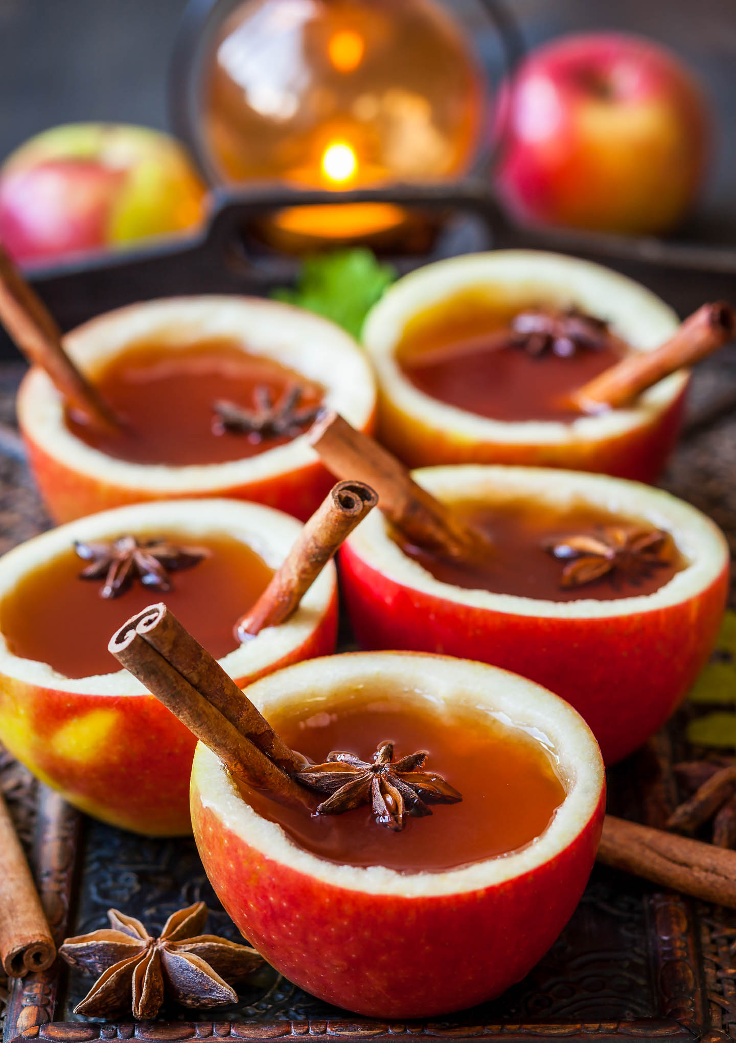 apple cups filled with spices and homemade apple cider