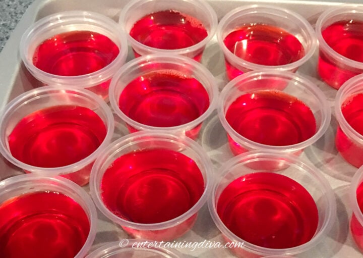 cherry fireball jello shots in jello shot cups on a cookie sheet