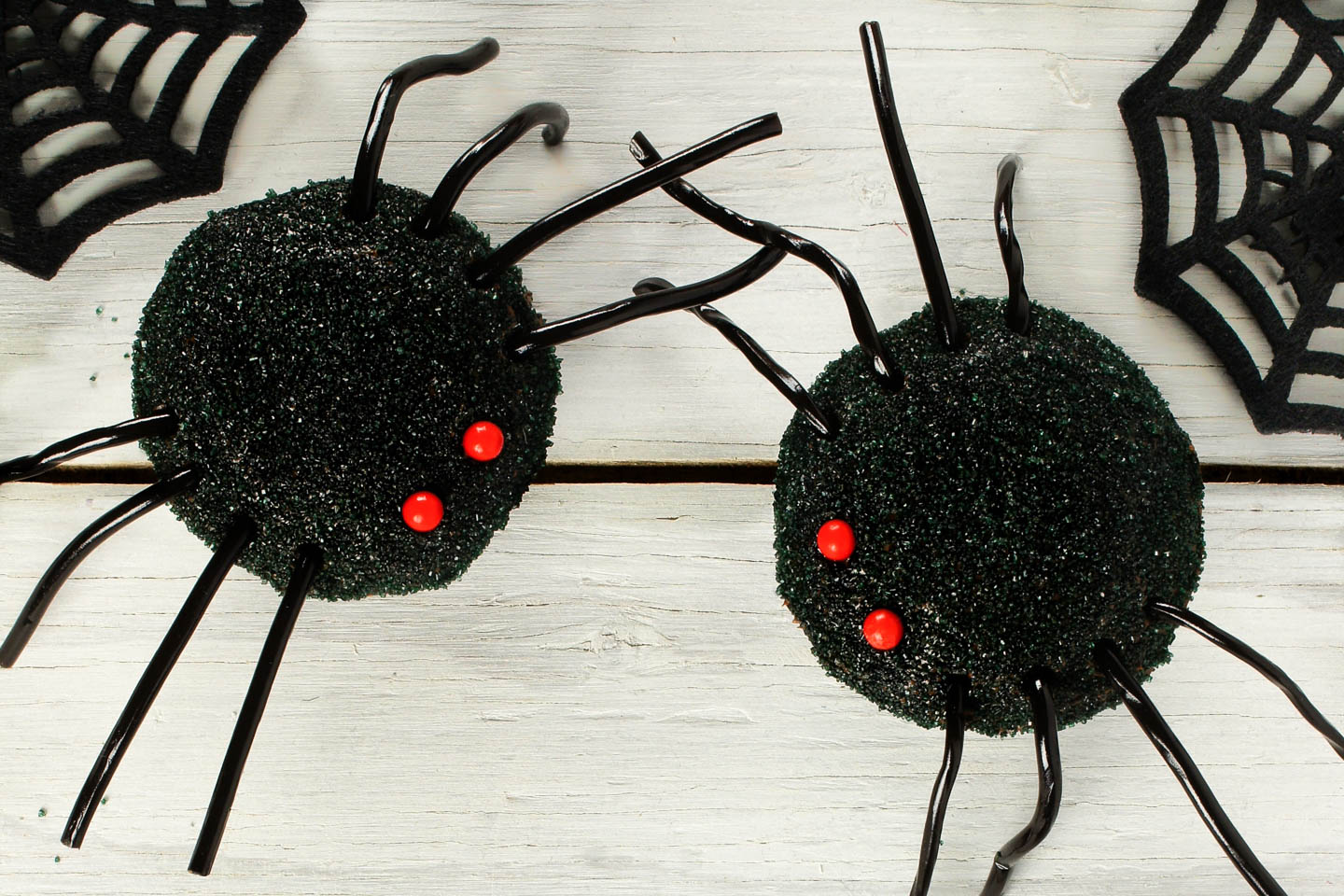 Halloween cupcake spiders with black sugar, red candy eyes and licorice string legs