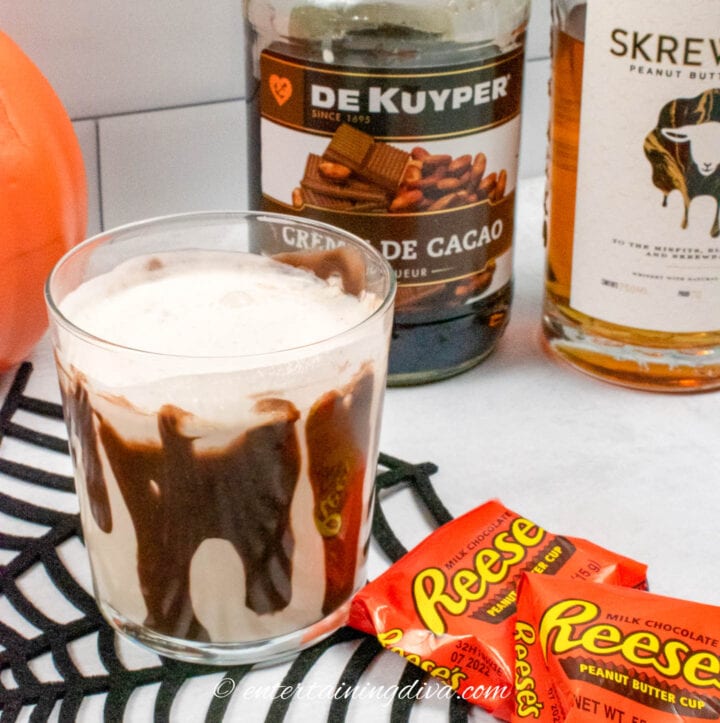 peanut butter cup cocktail with creme de cacao bottle and skrewball whiskey bottle in the background