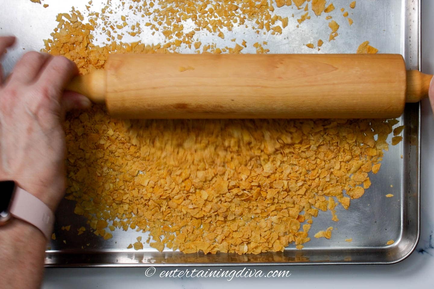 Corn flakes being crushed with a rolling pin