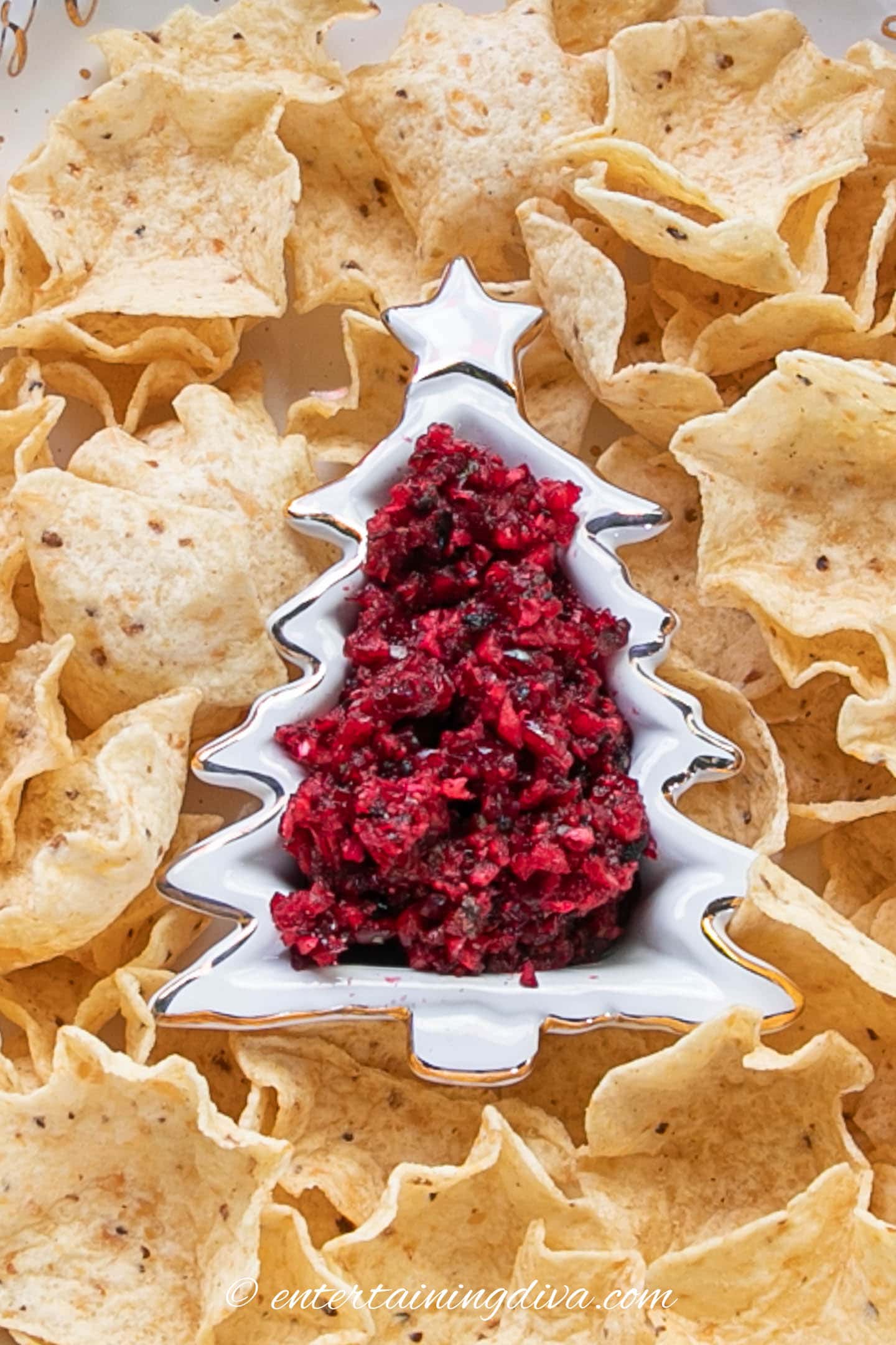 cranberry salsa in a Christmas tree serving bowl surrounded by chips