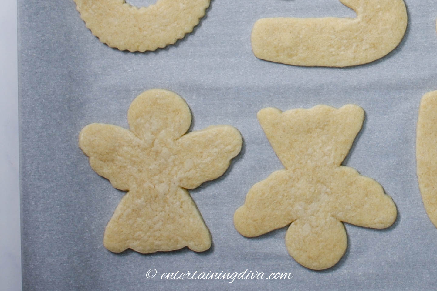 Christmas angel cookies on a baking sheet covered with parchment paper