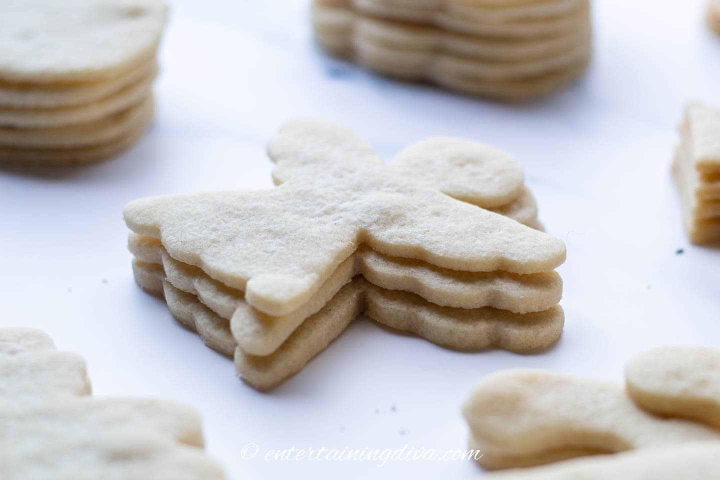 A stack of undecorated Christmas angel sugar cookies