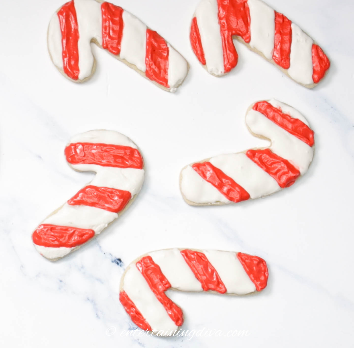 Candy cane sugar cookies with red and white royal icing stripes