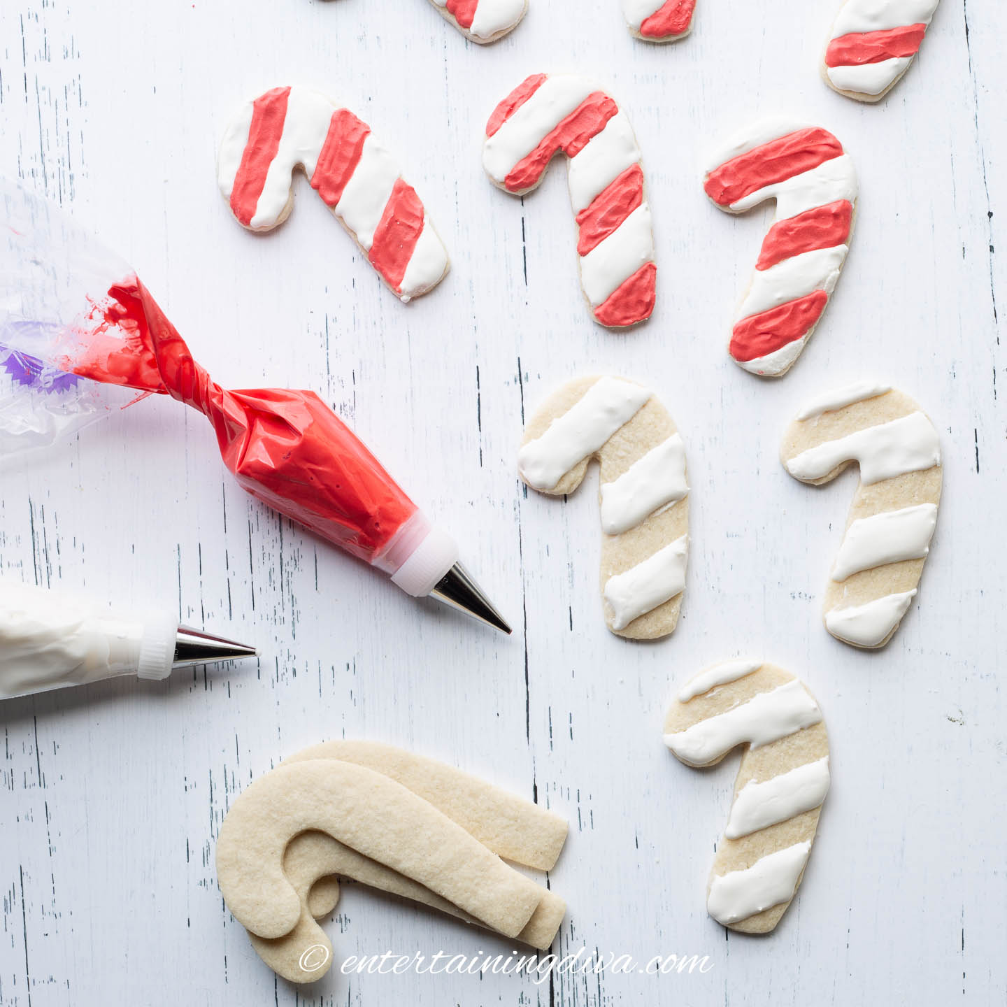 candy cane sugar cookies being decorated with red and white royal icing
