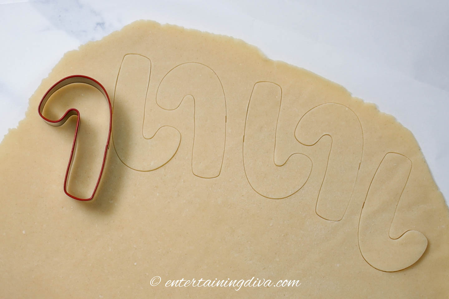 candy cane cookie cutter on rolled out dough