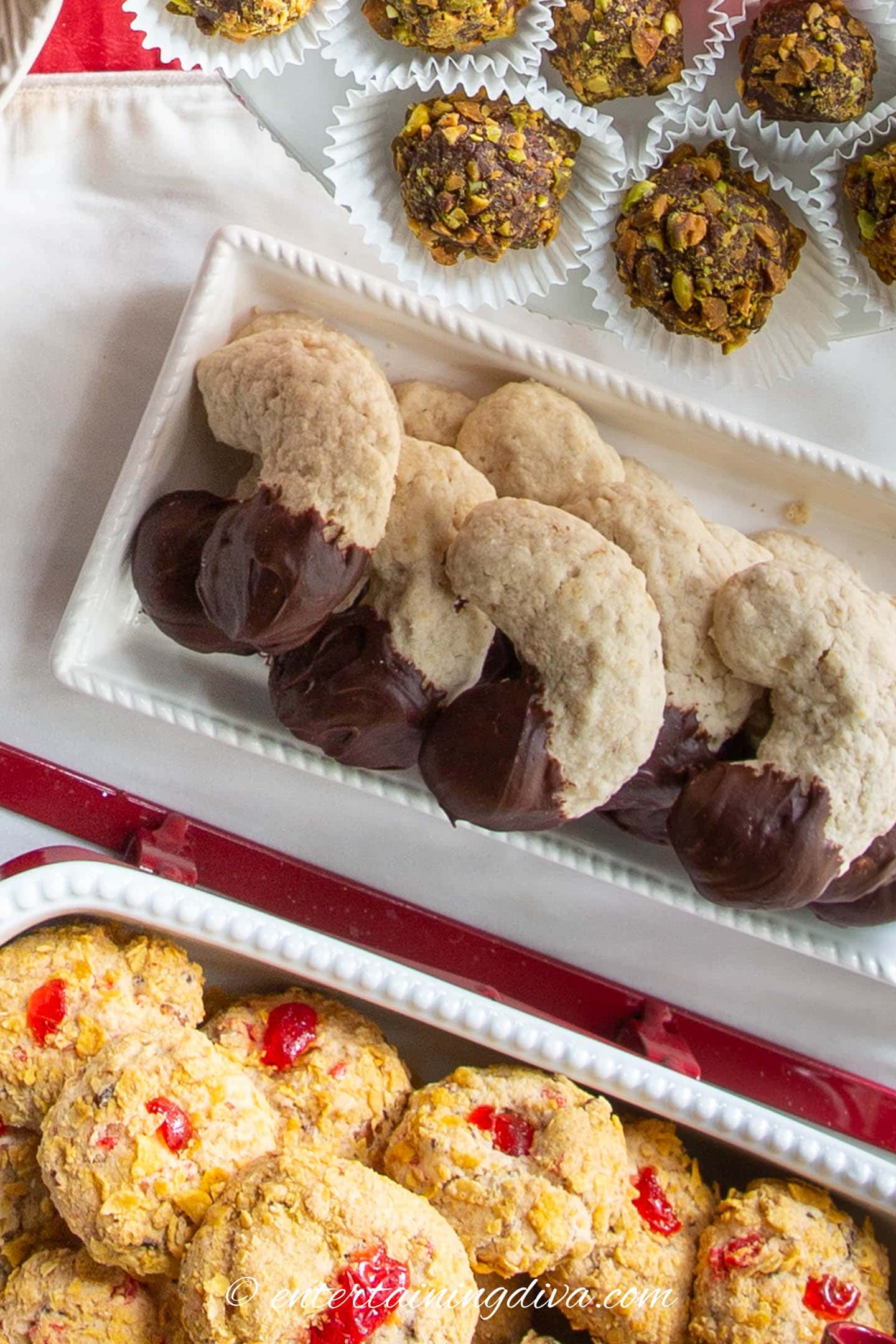 chocolate-dipped oatmeal crescent cookies on a Christmas cookie table