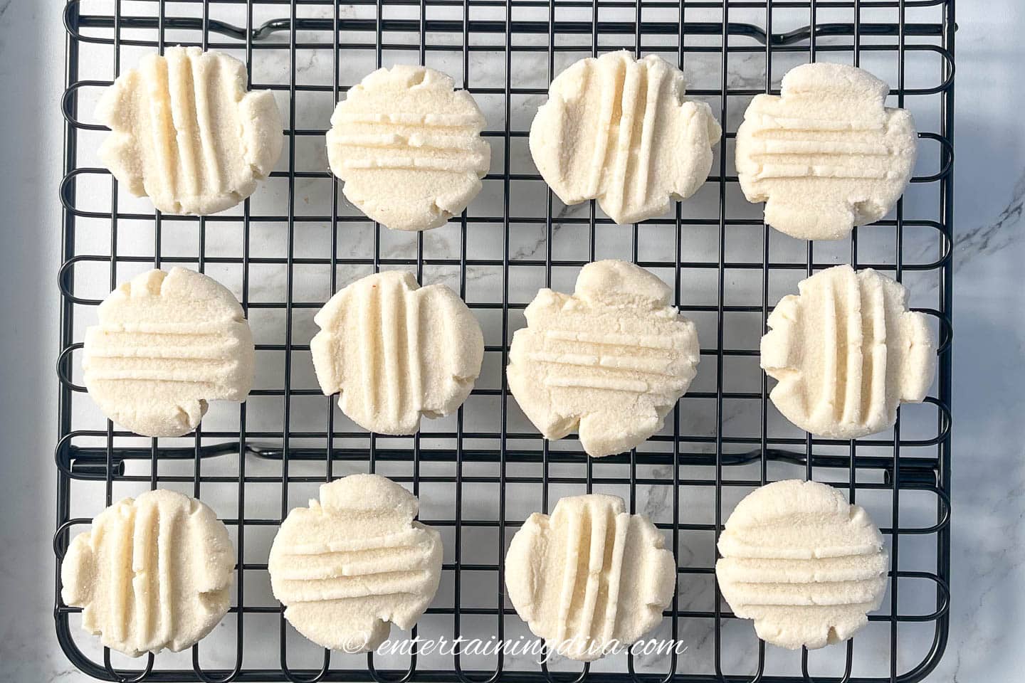whipped shortbread cookies with grooves in the top on a cooling rack