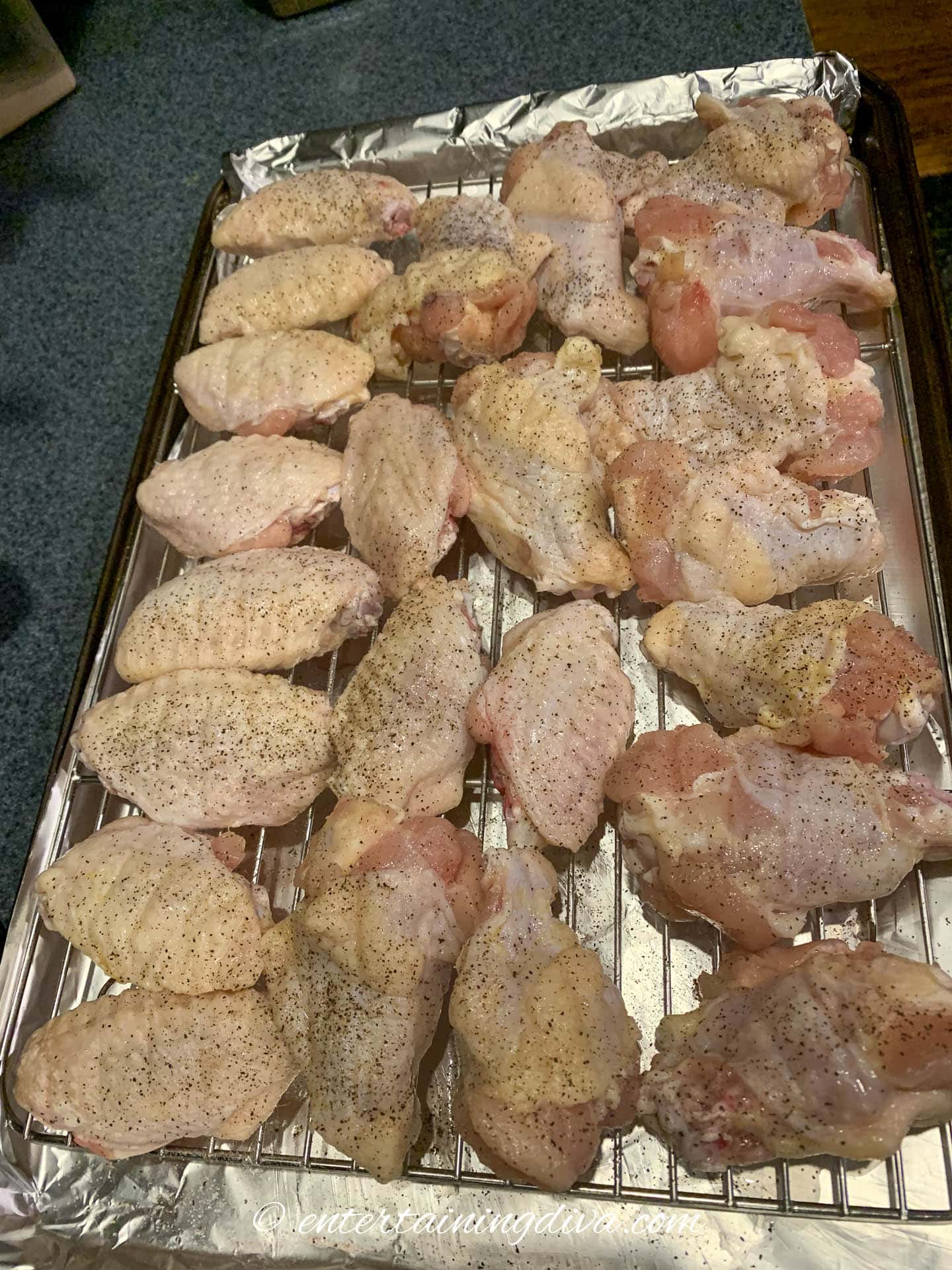 chicken wings on wire rack and baking sheet before baking