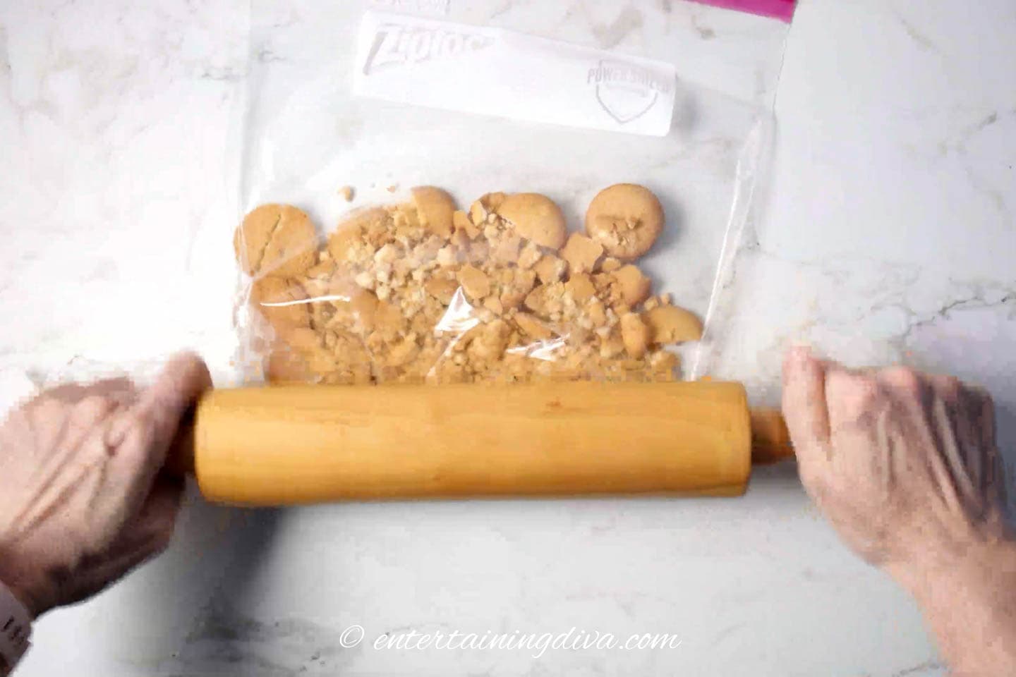 vanilla wafers being crushed with a rolling pin